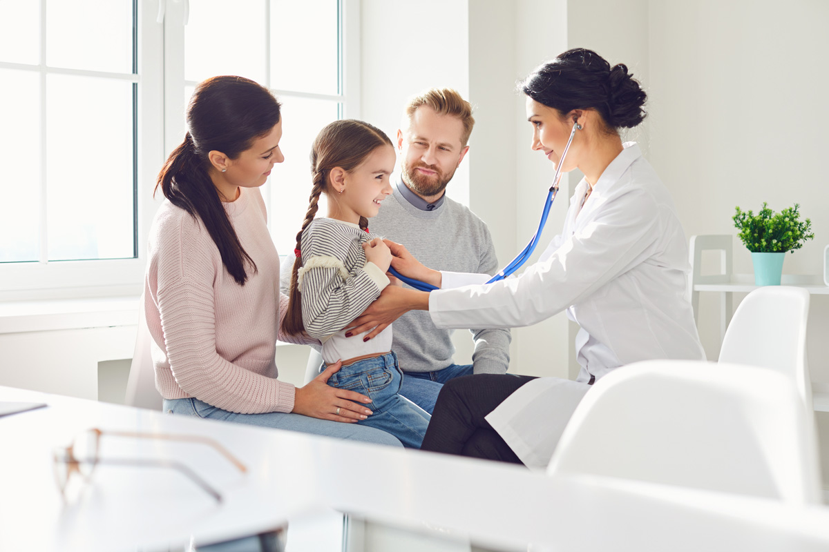 A doctor giving a child a checkup at a pediatric urgent care in El Paso.