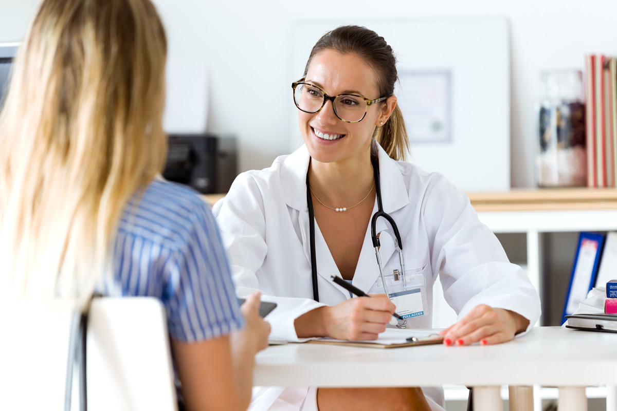 A doctor and patient having a conversation at a desk in an El Paso urgent care center.