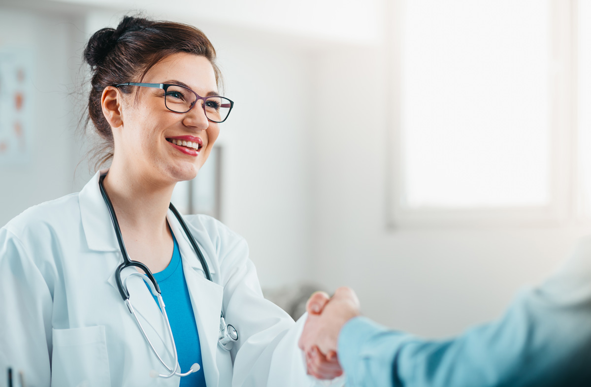 An urgent care physician shaking hands with a patient in El Paso.