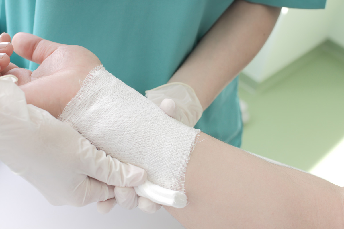 A person wrapping gauze around a patient’s wrist at an urgent care clinic in El Paso.